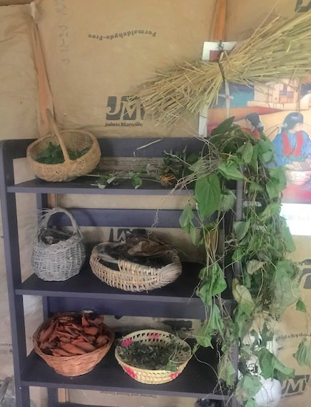 Herbs drying in baskets on grey painted shelves in Severina's Craft Studio